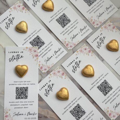 Heart-shaped chocolates on wedding invitation cards with QR codes for photo sharing.