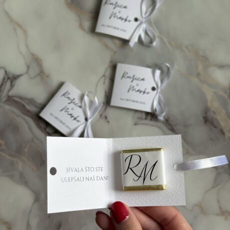 Elegant wedding favor with personalized monogram and heartfelt thank you message on a marble surface.