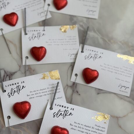 Love celebration wedding escort cards with red hearts and gold accents, perfect for romantic events.