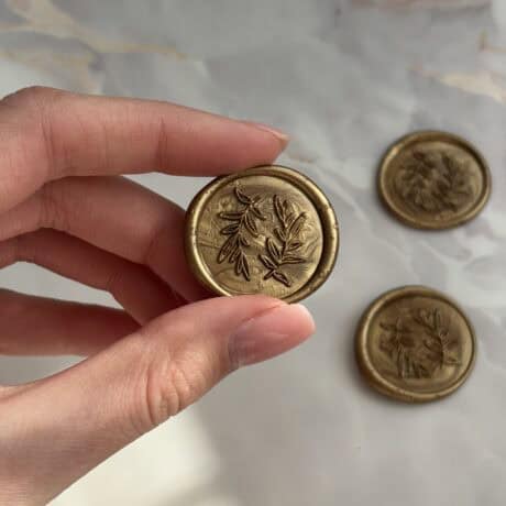 Elegant gold wax seal stamp with botanical leaf design for luxury branding and stationery.