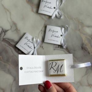 Elegant wedding favor with personalized monogram and heartfelt thank you message on a marble surface.
