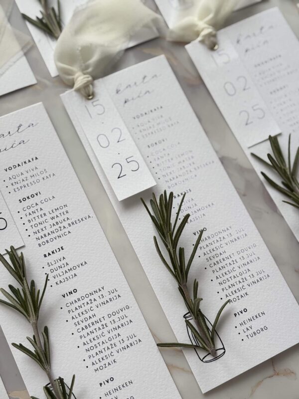 Elegant wedding menu cards with fresh rosemary sprigs for sophisticated event styling.