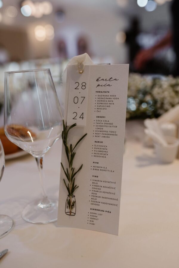 Elegant wine and beverage menu placed on a white tablecloth for a wedding reception.